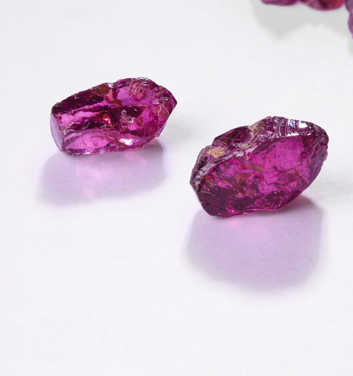 Two rough rhodolites on white.