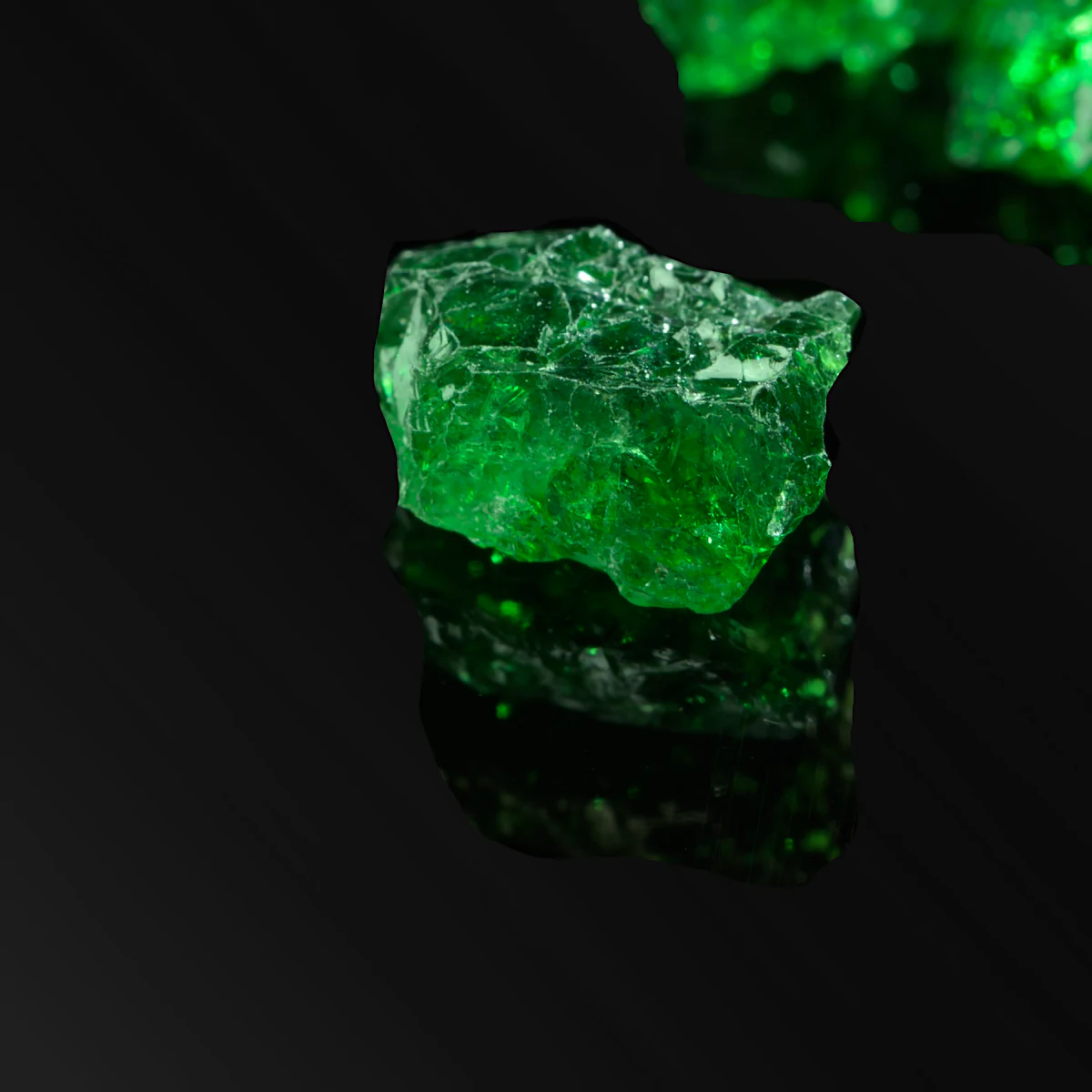 A single rough tsavorite crystal on black.