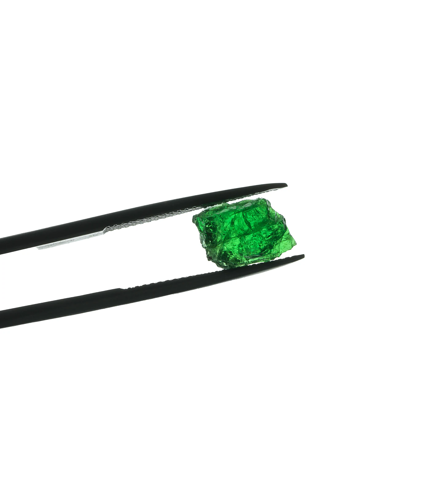 A rough tsavorite held in tweezers against white.